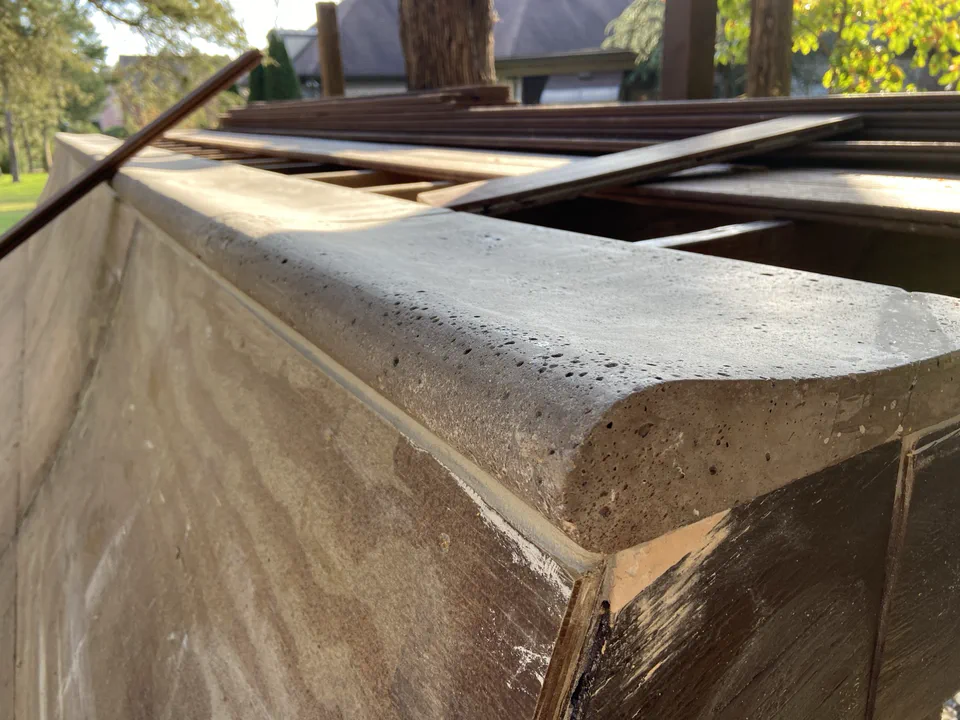 Coping set on the edge using thinset mortar to backerboard.