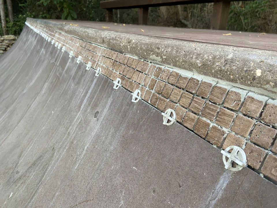 The upgrade: mosaic tile below the coping — new in the rebuild.