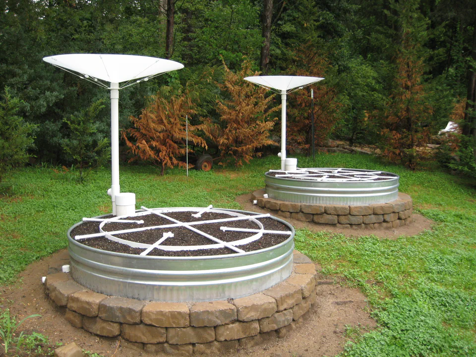 Both beds planted, with the inverted-cone rain catchers mounted on their masts.